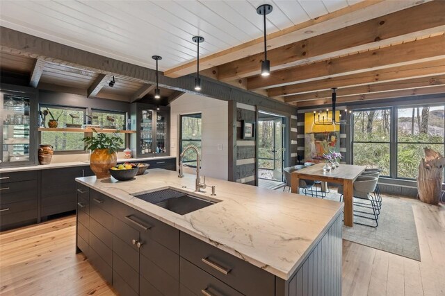 42 W Black Rock Cir, Highlands, NC 28741 - kitchen with light wood finished floors, pendant lighting, a kitchen island with sink, light stone countertops, and a wooden ceiling with exposed beams
