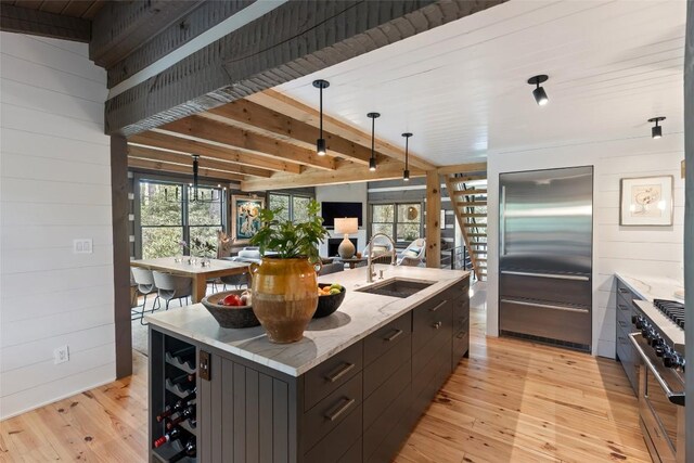 42 W Black Rock Cir, Highlands, NC 28741 - kitchen with premium appliances, light wood-style floors, a center island with sink, wood walls, and beam ceiling