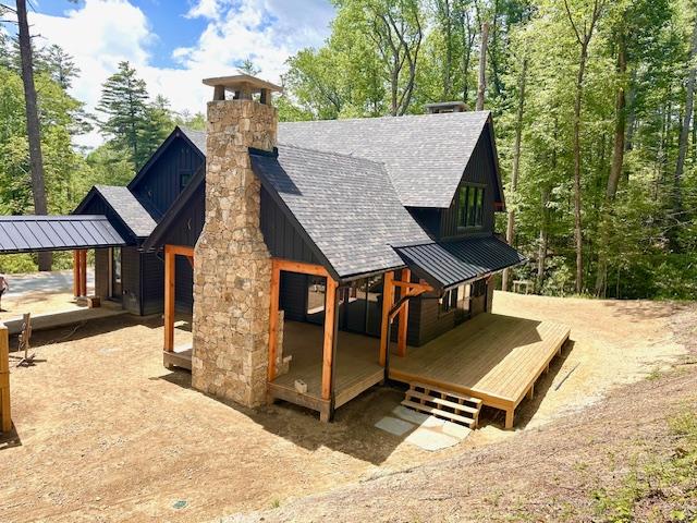 298 Pine Forest Rd, Sapphire, NC 28774 - back of property featuring a standing seam roof, board and batten siding, a shingled roof, a chimney, and a metal roof