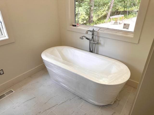 298 Pine Forest Rd, Sapphire, NC 28774 - bathroom featuring marble look tiles and a freestanding bath