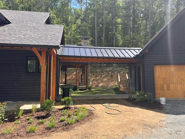 298 Pine Forest Rd, Sapphire, NC 28774 - view of home's exterior with a standing seam roof, an attached garage, and a metal roof