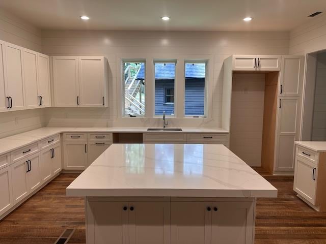 298 Pine Forest Rd, Sapphire, NC 28774 - kitchen with dark wood-style flooring, white cabinetry, light stone countertops, a center island, and recessed lighting