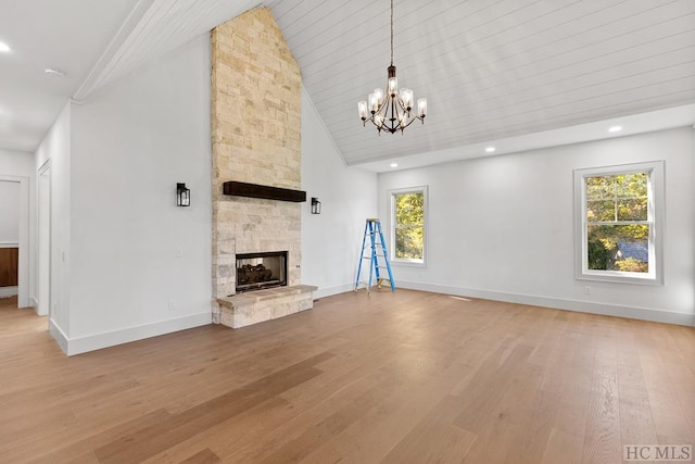 unfurnished living room featuring high vaulted ceiling, a wealth of natural light, a fireplace, and light hardwood / wood-style flooring