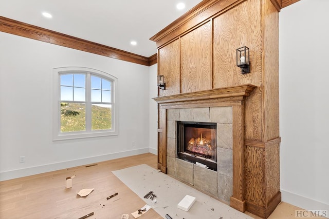 living room with a tiled fireplace and crown molding