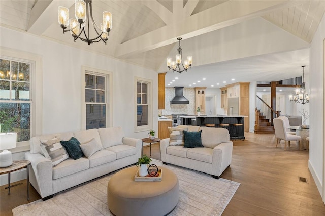 343 Ledgeview Rd, Cashiers, NC 28717 - living room featuring a chandelier, vaulted ceiling, light wood-type flooring, and stairs