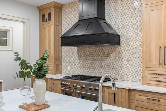 343 Ledgeview Rd, Cashiers, NC 28717 - kitchen with backsplash, custom range hood, range with two ovens, light stone counters, and glass insert cabinets