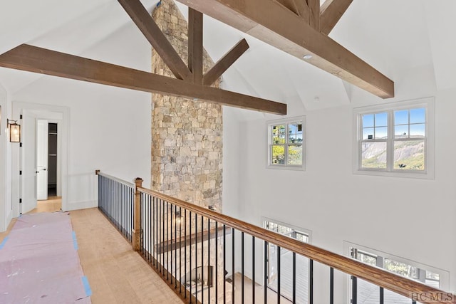 hall with vaulted ceiling with beams and light hardwood / wood-style flooring