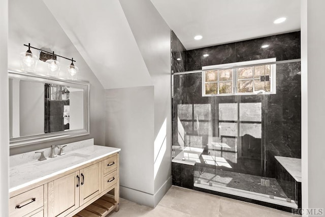 bathroom with vaulted ceiling, vanity, and a shower with door