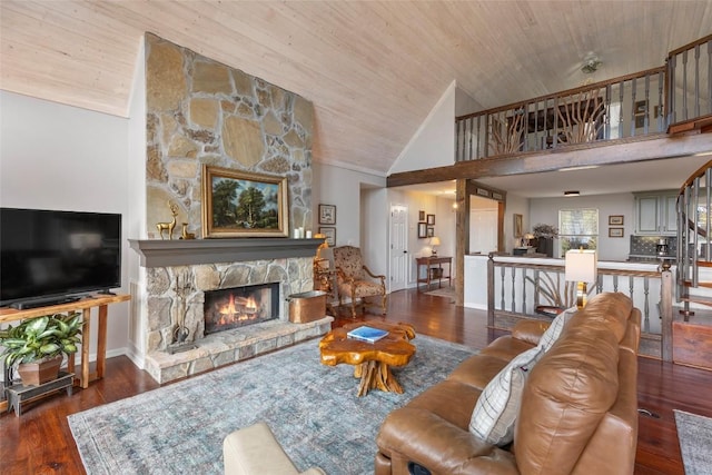 living room featuring baseboards, wooden ceiling, wood finished floors, and a fireplace