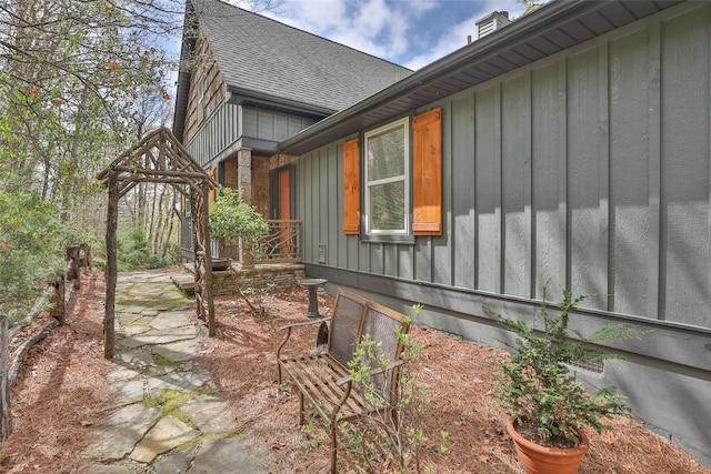 view of home's exterior with a shingled roof and board and batten siding