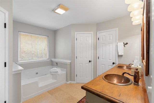 bathroom featuring a sink, a bath, and tile patterned floors