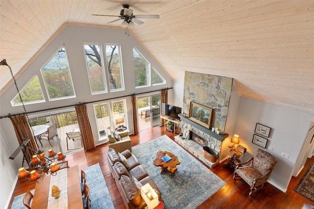 living room featuring plenty of natural light, a ceiling fan, wood finished floors, and wooden ceiling