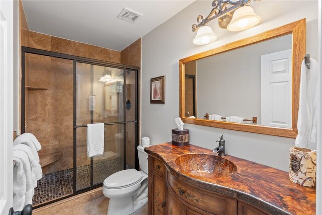 bathroom with visible vents, a stall shower, toilet, and vanity