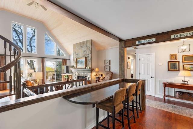 bar with lofted ceiling with beams, a fireplace, dark wood-style flooring, and visible vents