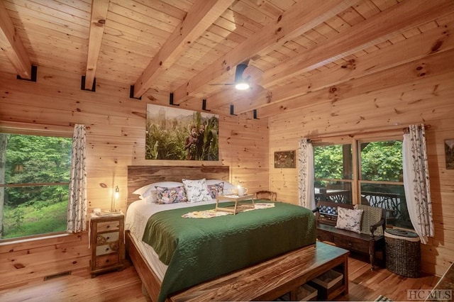 bedroom with wooden walls, wooden ceiling, and beam ceiling