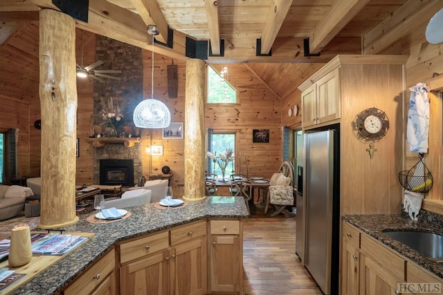 kitchen with beam ceiling, wood ceiling, wood walls, and stainless steel fridge with ice dispenser