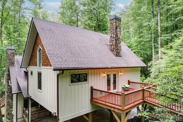 rear view of property featuring a wooden deck and french doors