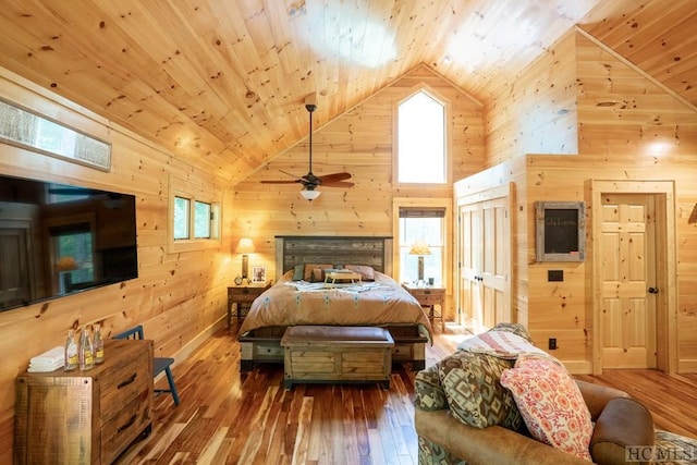 bedroom featuring high vaulted ceiling, hardwood / wood-style floors, wooden ceiling, and wood walls