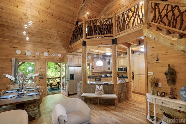 living area with light hardwood / wood-style flooring, high vaulted ceiling, wood walls, and wooden ceiling