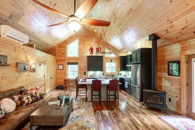 interior space with a wood stove, wood ceiling, a wall unit AC, wood walls, and wood-type flooring