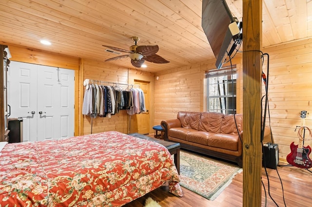 bedroom featuring light wood-type flooring, wooden walls, wood ceiling, and ceiling fan