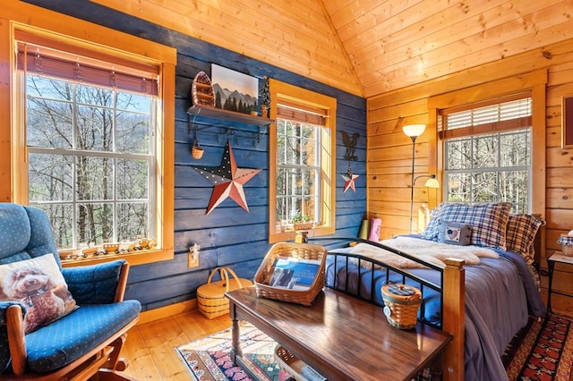 bedroom featuring hardwood / wood-style floors, lofted ceiling, and wood walls