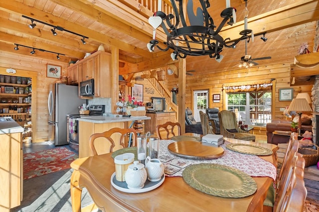 dining area featuring ceiling fan and wood walls