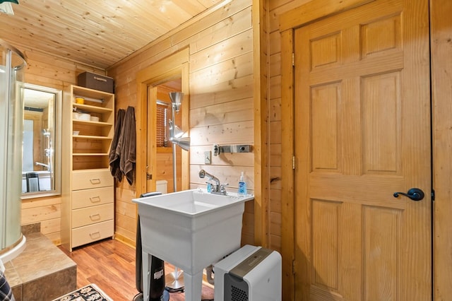 bathroom featuring sink, wooden ceiling, hardwood / wood-style floors, and wooden walls