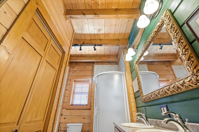 kitchen with track lighting, wood ceiling, wood walls, beamed ceiling, and sink