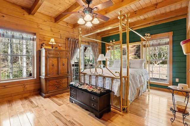 bedroom with light hardwood / wood-style floors, wood walls, and wooden ceiling