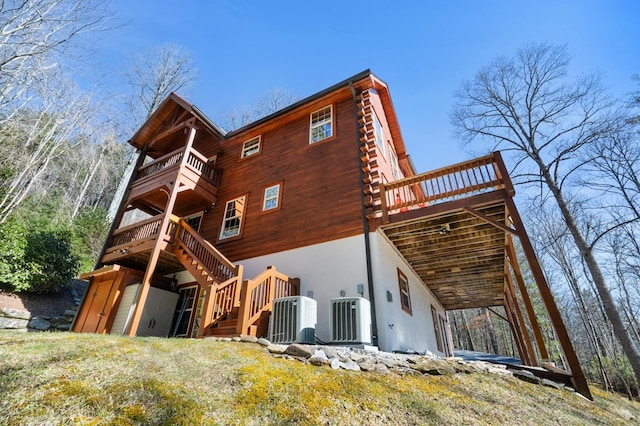 back of property with central air condition unit and a balcony