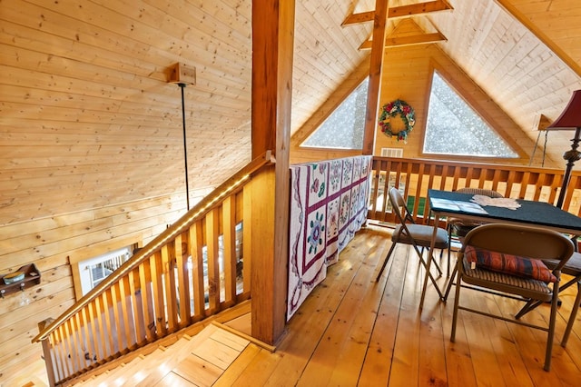 additional living space featuring lofted ceiling with beams, wood ceiling, wood walls, and light wood-type flooring