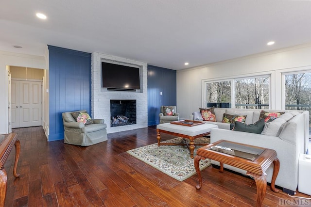 living room with ornamental molding, dark hardwood / wood-style floors, and a fireplace