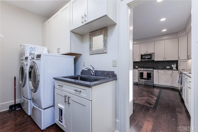 clothes washing area with a sink, laundry area, recessed lighting, dark wood-style flooring, and separate washer and dryer