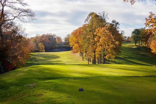 view of home's community with view of golf course and a yard