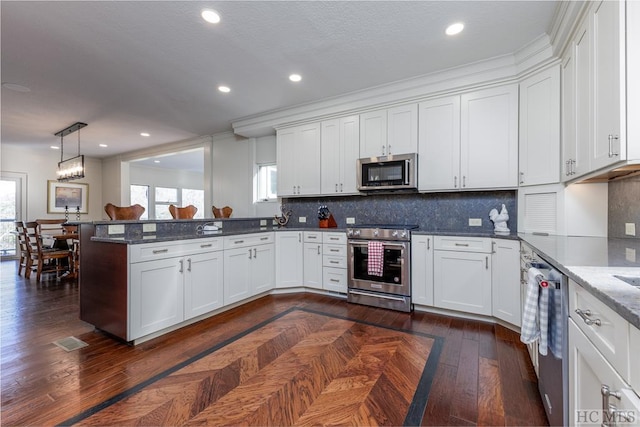 kitchen featuring white cabinets, pendant lighting, and stainless steel appliances