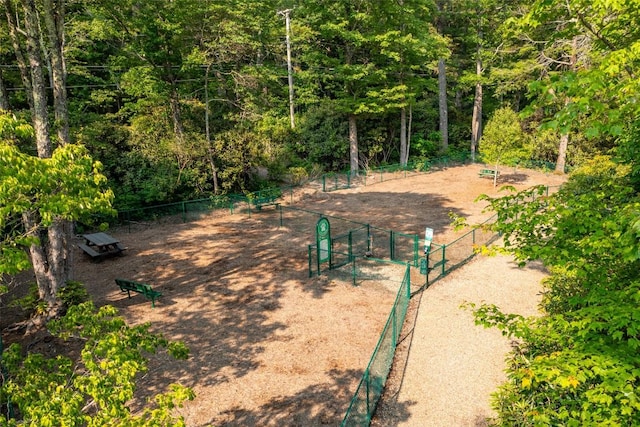 view of community with fence and a wooded view