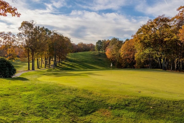 view of home's community featuring golf course view and a yard