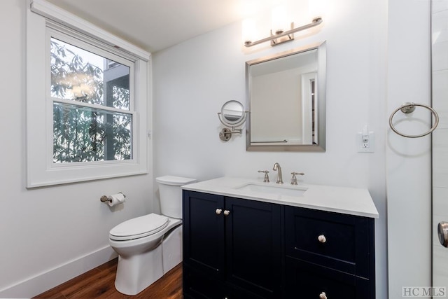 bathroom with wood-type flooring, vanity, and toilet