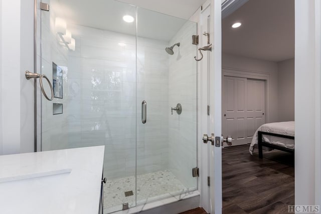 full bath with a shower stall, recessed lighting, and wood finished floors