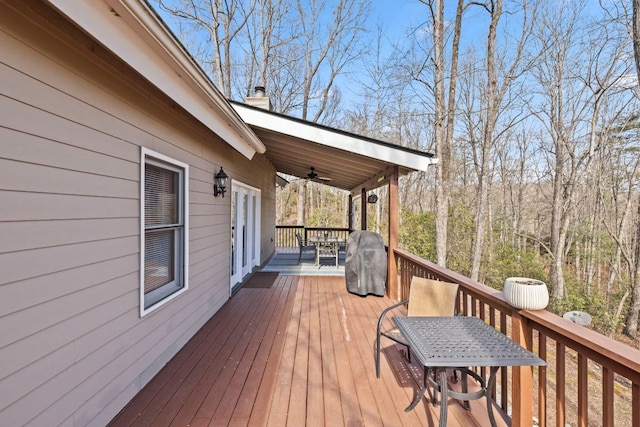 wooden terrace featuring outdoor dining area and ceiling fan