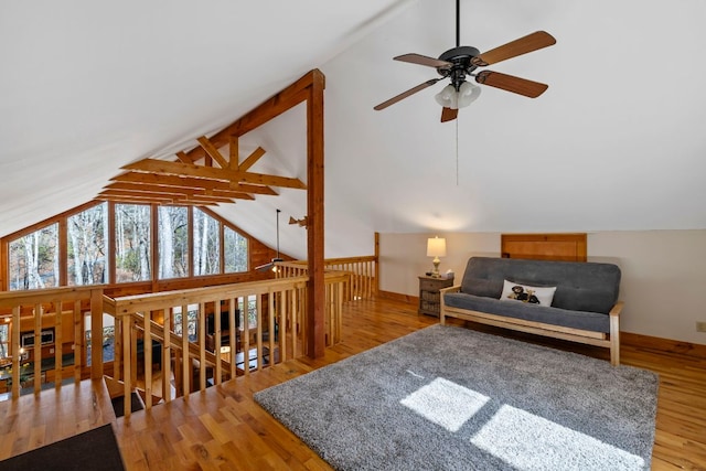 living area with lofted ceiling with beams, baseboards, and wood finished floors