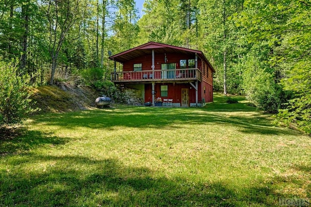 rear view of house featuring a lawn and a deck