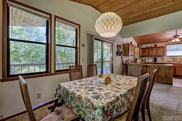 carpeted dining area featuring lofted ceiling, sink, and wooden ceiling