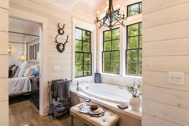421 Easter Ln, Cullowhee, NC 28723 - bathroom with a chandelier, a bath, wooden walls, wood finished floors, and ensuite bathroom