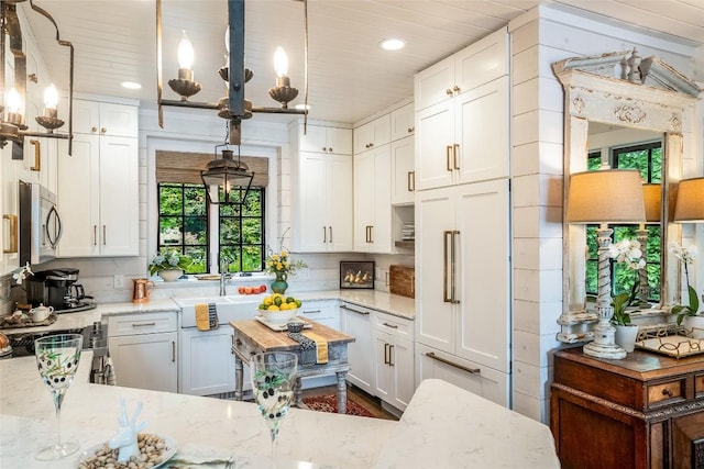 421 Easter Ln, Cullowhee, NC 28723 - kitchen with stainless steel microwave, white cabinets, recessed lighting, light stone countertops, and wooden ceiling