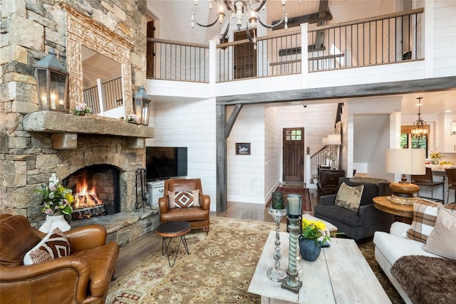 421 Easter Ln, Cullowhee, NC 28723 - living room featuring a chandelier, a towering ceiling, stairway, wood finished floors, and a stone fireplace