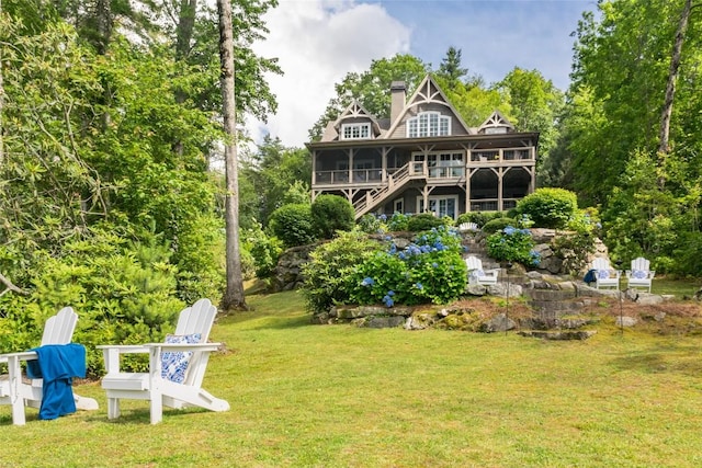 421 Easter Ln, Cullowhee, NC 28723 - rear view of property with a yard, a sunroom, stairs, a wooden deck, and a chimney