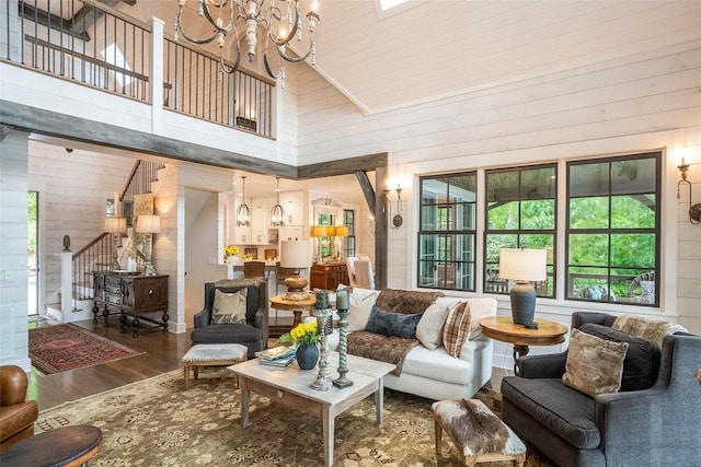 421 Easter Ln, Cullowhee, NC 28723 - living area with a towering ceiling, wood walls, a chandelier, wood finished floors, and stairs