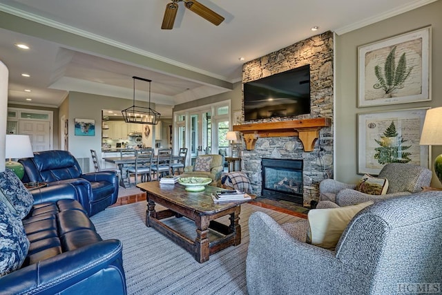 living room featuring a fireplace, ornamental molding, and ceiling fan